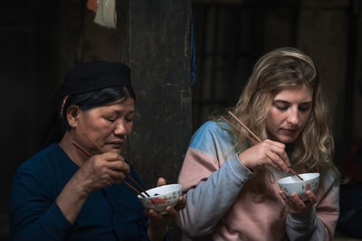 两个女人用筷子吃饭
